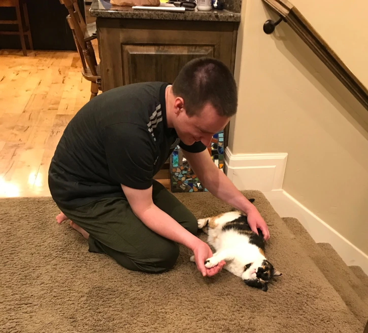 Elbert John Eastmond petting a cat